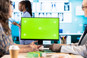 Medic and woman patient discuss about a new treatment plan next to green screen, reviewing the...