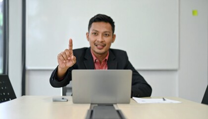 Man Gesturing to Interject with Raised Finger and Blurred Meeting Table