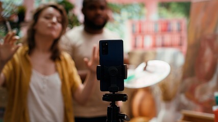 Female artist explaining painting techniques used on online tutorial, recording vlog for art class...