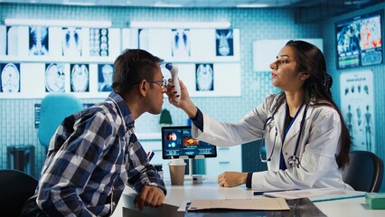 Medic expert uses a thermometer to find the right diagnostic and symptoms, showcasing modern healthcare practices to support patients on medical insurance services. Fever measurements. Camera B.