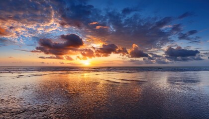 Obraz premium vibrant sunset over the ocean with dramatic clouds and reflections