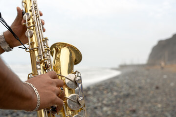 Saxophonist playing sax on the beach seeking inspiration
