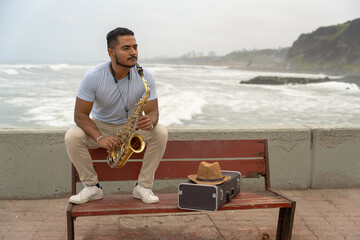 Saxophonist finding inspiration playing sax on the beach