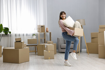 Moving day. Happy woman with her belongings in new home
