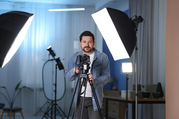 Man with professional video camera in studio