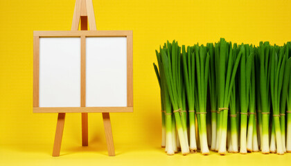 freshly picked green onion feathers in bunches lie near a billboard on a yellow background