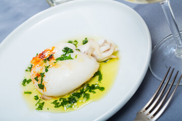 Appetizer cooked fried sepia with green sauce from olive oil and garlic, served with parsley
