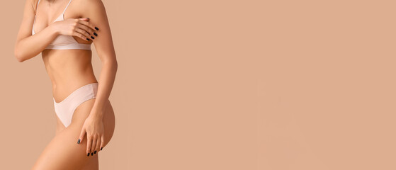 Young woman in underwear with cellulite problem on beige background, closeup