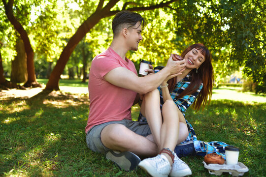 Happy Young Couple Enjoying Picnic in Sunny Park