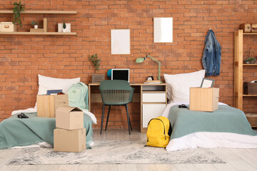 Interior of dorm room with beds, table and moving boxes