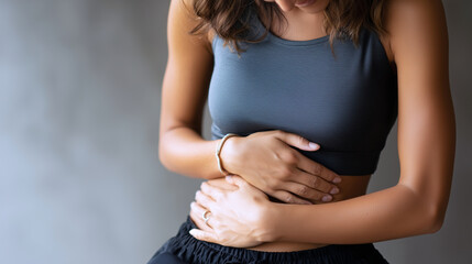 Woman clutching stomach from abdominal pain
