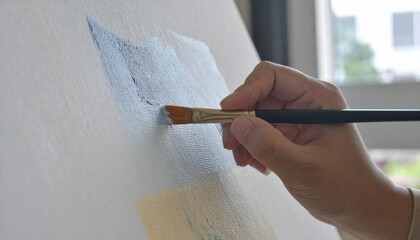 a hand hold brush to paint on canvas