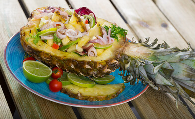 Image of stuffed pineapple with squid and lime. Seasoned by sauce of pineapple juice, lemon, olive oil, lime and chili pepper