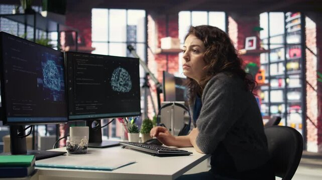IT technician writing code and debugging on artificial intelligence neural networks computerized brain model. Female tech support doing checkup on AI systems, cloud computing. Camera A.