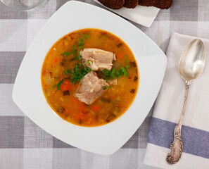 Rassolnik, russian soup made of pearl barley, pickled cucumbers and meat. Portion of soup.
