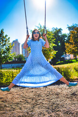 Joyful Young Woman Swinging High Outdoors on Sunny Day