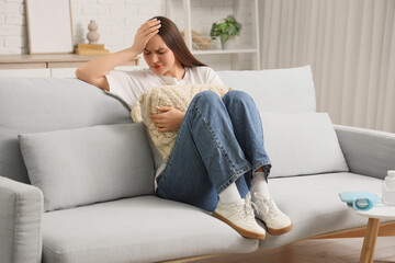 Young woman suffering from menstrual cramps  at home