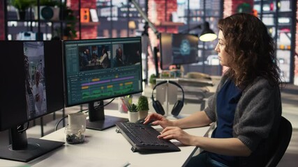 Female expert editor working in video production industry at agency office, doing color grading and creating a montage on dual monitors. Creative process with multimedia tech tools. Camera A.