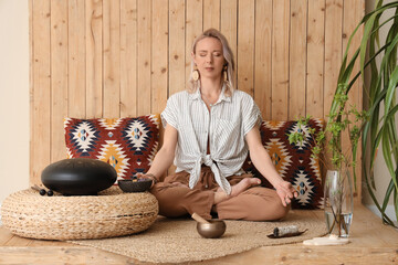 Woman meditating while practicing yoga at home