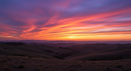 Naklejka premium Rolling Hills Landscape at Fiery Sunset with Vibrant Sky