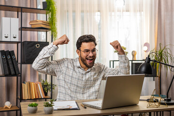 Happy amazed Indian businessman working on laptop shocked by sudden victory, game winning lottery...