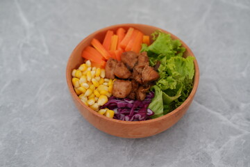 Colorful and Healthy Chicken Salad in a Wooden Bowl