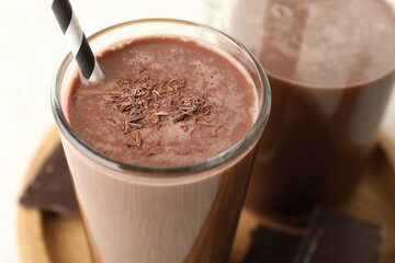 Tasty chocolate milk with shavings on white table, closeup