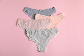 Women's underwear. Beautiful panties on pink background, flat lay
