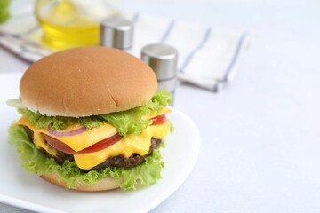 Tasty cheeseburger on white table, closeup. Space for text