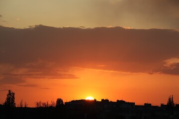 Buildings and trees under beautiful sky at sunset