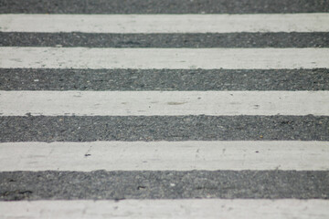 Zebra crosswalk on a asphalt road - closeup background	