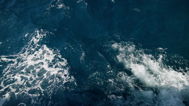 Ocean waves breaking, creating white foam against deep blue waters, showcasing natural marine dynamics for documentary and background footage