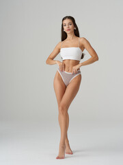 Fototapeta premium Fashion model showcases studio elegance with striking pose and stylish attire