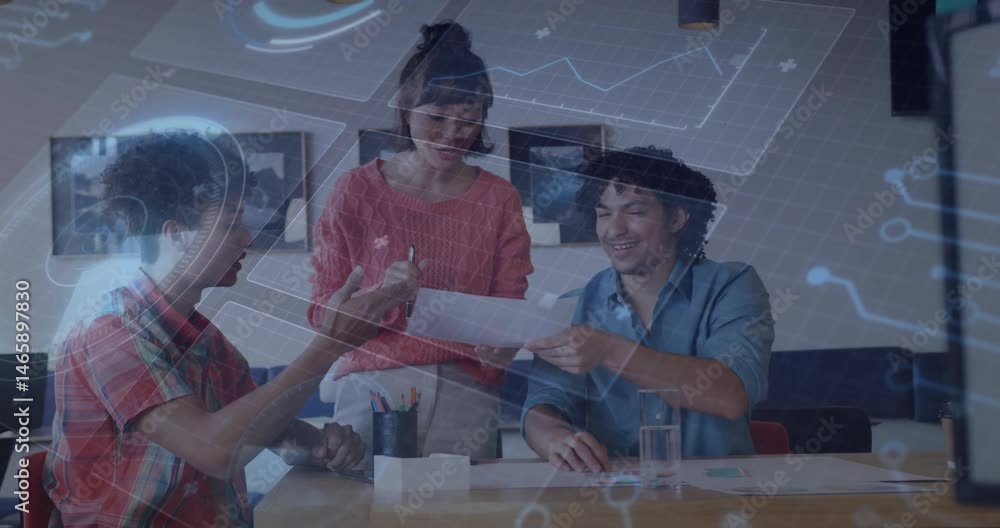 Poster tech colleagues reviewing documents around table, displaying holographic graphs and circuitry