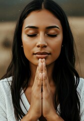 Naklejka premium Woman Praying with Eyes Closed Outdoors
