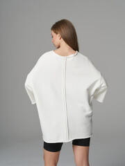 Model showcasing contemporary fashion in minimalistic studio setting