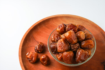 Dates fruit sukari or kurma sukari, in wooden bowl isolated on white background