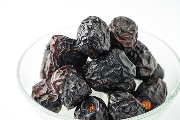 Dates fruit ajwa or kurma ajwa, in bowl isolated on white background