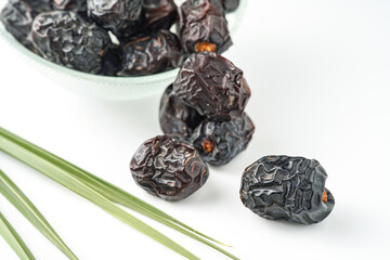 Dates fruit ajwa or kurma ajwa, in bowl isolated on white background