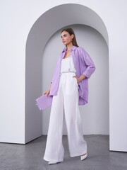Fashionable female model showcases tranquil elegance in a modern studio setting