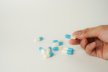 Male hand holding white capsule pill, isolate background, pharmacy, medicine, health care