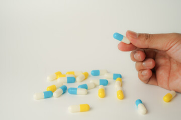 Male hand holding white capsule pill, isolate background, pharmacy, medicine, health care