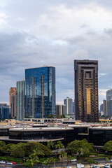 Obraz premium Urban Skyline in Honolulu Featuring Modern Architecture with Cloudy Sky