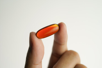 Male hand holding Oil filled capsules, softgel of food supplements, fish oil, omega 3, vitamin E