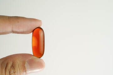 Male hand holding Oil filled capsules, softgel of food supplements, fish oil, omega 3, vitamin E
