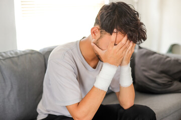 Sad Young Guy With Bandages On Wrists After Suicide Attempt
