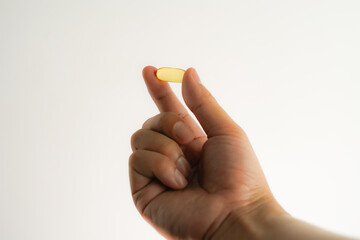 Male hand holding soft gels, Fish oil capsules, omega 3, omega 9, vitamin D, vitamin E, supplements