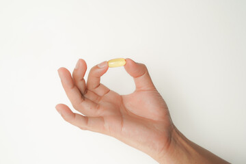 Male hand holding soft gels, Fish oil capsules, omega 3, omega 9, vitamin D, vitamin E, supplements