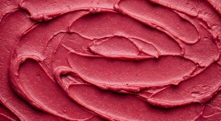 Close-up of vibrant red frosting swirled atop ice cream, evoking a summer treat with rich texture and color