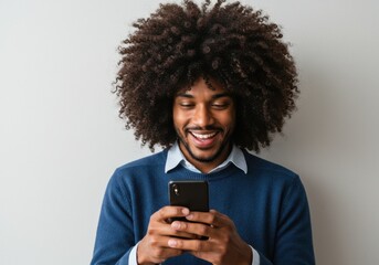 Man smiling while looking at a mobile device in his hands now